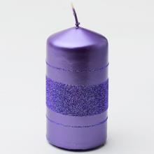 Fialová vianočná sviečka s glitrom a pruhmi.