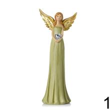 Dekoračný anjel so srdcom a zlatými krídlami.