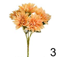 Kytica umelých kvetov s dáhliami a zelenými listami.