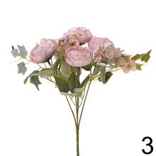 Kytica umelých kvetov s ranunculusmi a brečtanom.