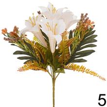 Kytica umelých kvetov s ľaliami, bobuľkami a zeleňou.