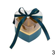 Darčeková krabička na kvety v tvare srdca s rôznymi farbami a stuhou.