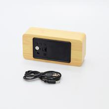 Digitálne LED hodiny s dreveným vzhľadom.