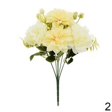 Umelá kytica s bielymi kvetmi a zelenými listami.