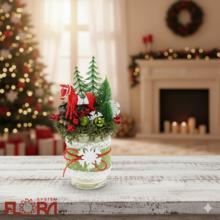 Vianočné aranžmá s červeným koníkom a zelenými stromčekmi.