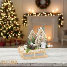 Vianočné aranžmá na saniach s domčekmi a snehuliakom.