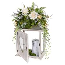 Smútočná väzba s kvetinami v drevenej lucerne srdcového tvaru.