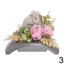 Smútočná väzba s ružovými kvetmi a zelenými listami.