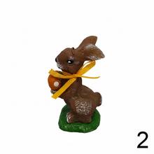 Hnedý zajac s vajíčkom a žltou stuhou.