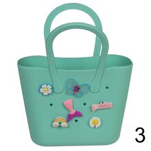 Kabelka s príveskom v rôznych farbách.