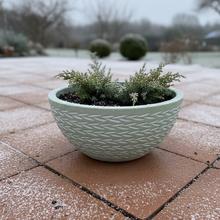 Zelená keramická misa s dekoratívnym vzorom.