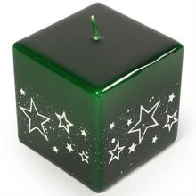 Zelená svíčka ve tvaru kostky s bílými hvězdami.