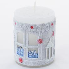 Vánoční svíčka s krajinkou a dekoracemi.