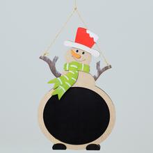Sněhulák s červenou čepicí a zeleným šálou, dřevěná tabule na zavěšení.