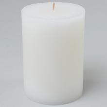 Bílá vánoční svíčka ve skleněném obalu.