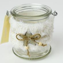 Bílý svícen s kožešinou a skleněným tělem.