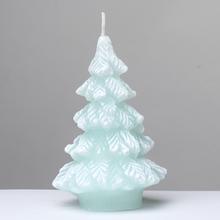 Vánoční svíčka ve tvaru stromečku v pastelové mátě.