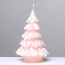 Růžová vánoční svíčka ve tvaru stromečku.