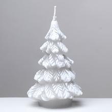 Šedá vánoční svíčka ve tvaru stromečku.