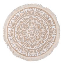 Bílý ubrus s ornamentálním vzorem, průměr 40 cm.