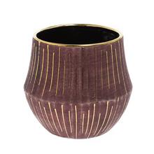 Kulatý obal burgundské barvy se zlatými pruhy.