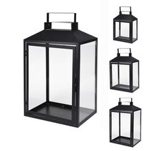 Černý kovový lampáš s průhlednými stěnami.