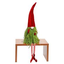 Sedačkový skřítek v červeném a zeleném oblečení s dlouhým červeným kloboukem.