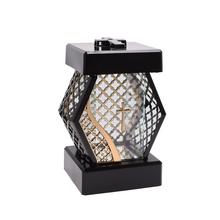 Malá lucerna s křížem a diamantovým designem.