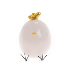 Porcelánové kuřátko s bílým a zlatým povrchem.