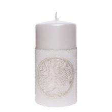 Bílá svíčka s dekorativním vzorem.