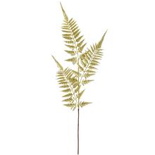 Zlatá větev kapradiny s metalickým a třpytivým povrchem.