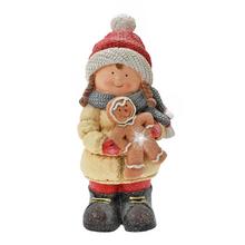 Dívka s perníkem v zimním oblečení.