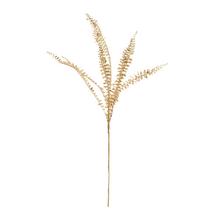 Zlatá větev kapradiny s metalickým leskem.