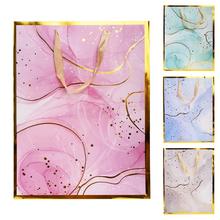 Dárková taška M s různými vzory v pastelových barvách.