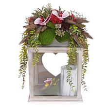 Smuteční vazba s dekorativní lampou a květinovou aranžmá.