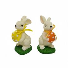 Figurka zajíce s vajíčkem v krémové barvě.